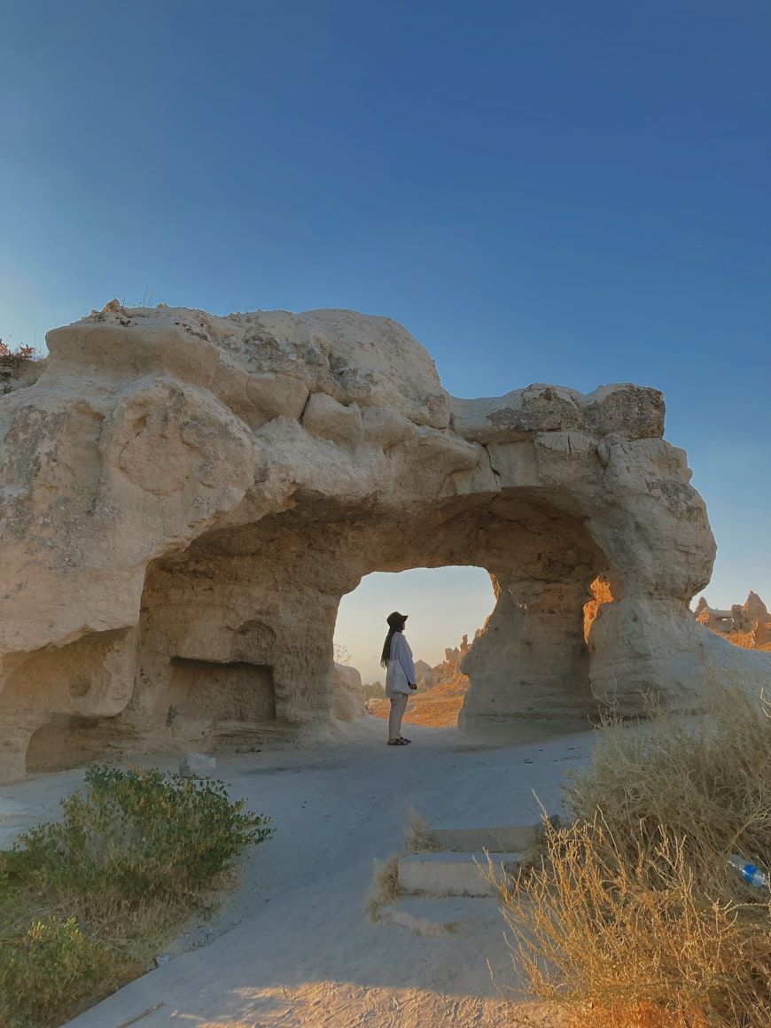a person standing in front of a rock formation